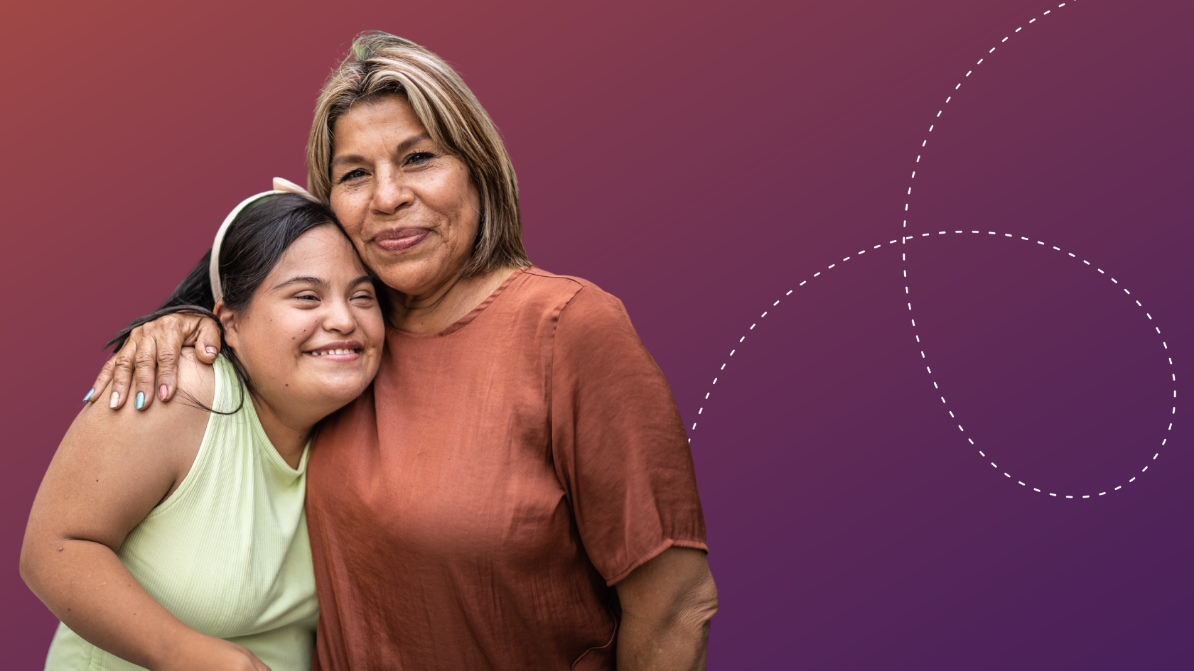 Two women giving each other a side hug and posing for a photo.