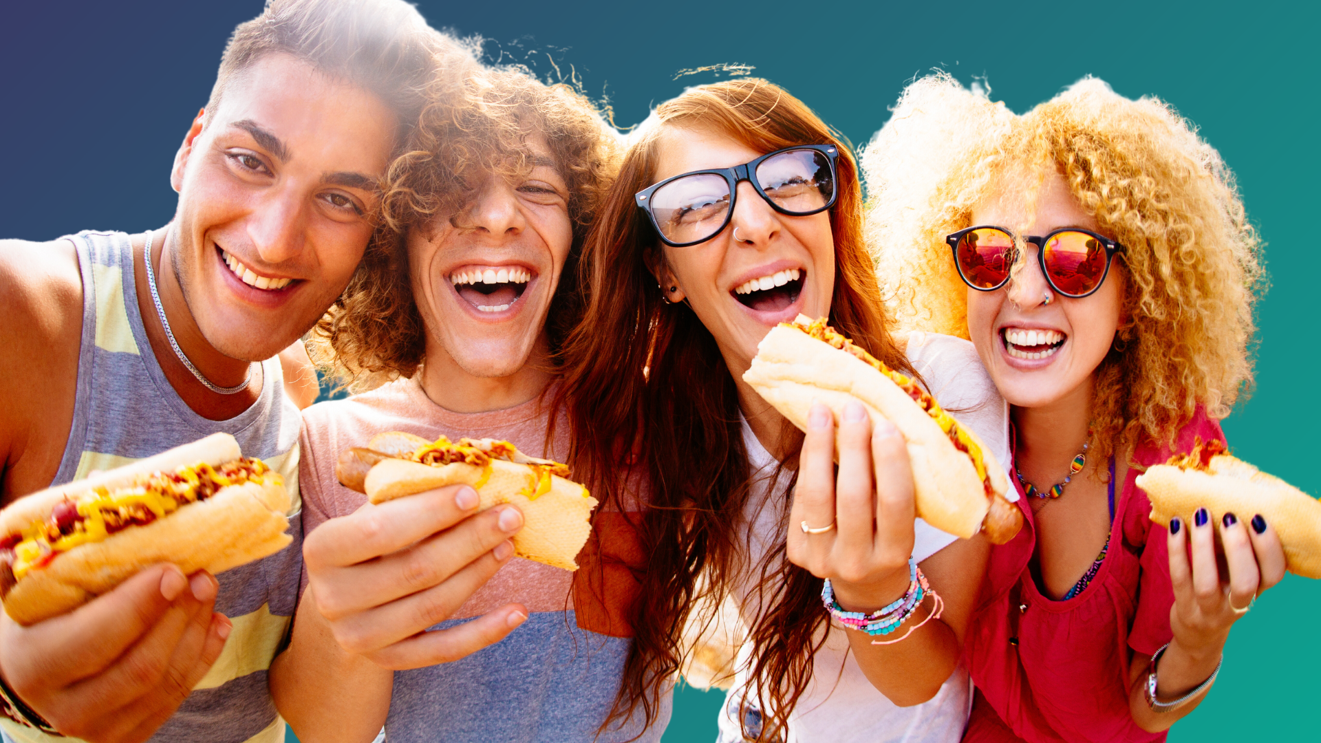 Four friends wearing sunglasses and posing for a photo while eating hotdogs.
